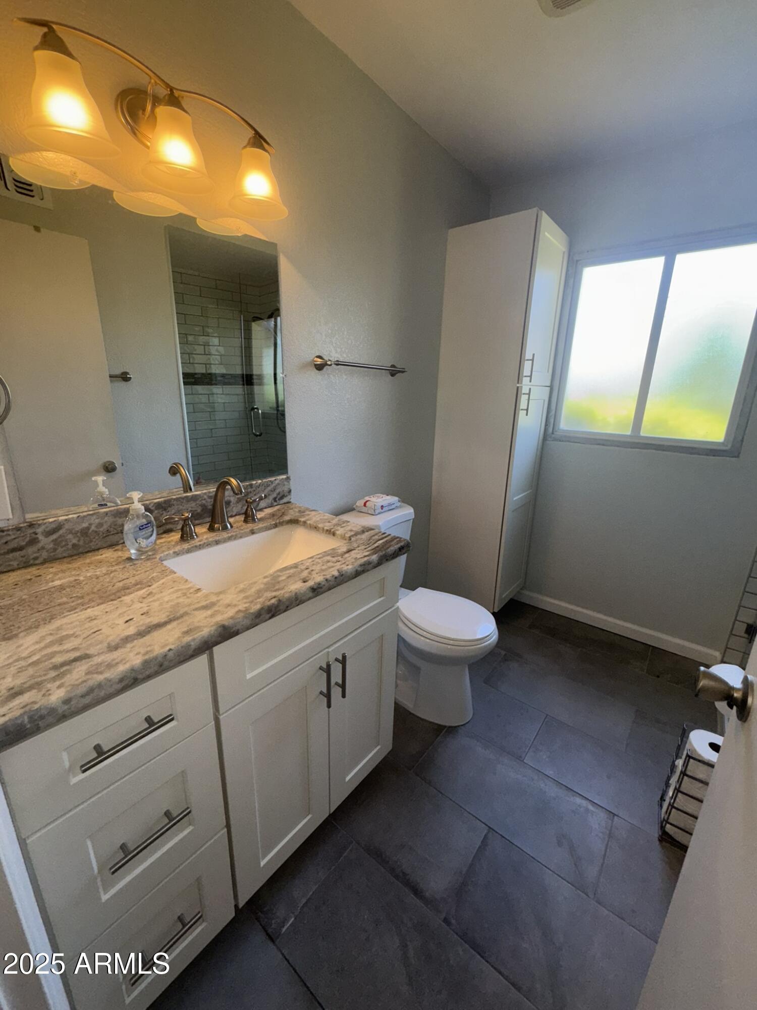 131 North Higley Road, Unit 71 Mesa, AZ 85205 - Photo 8 of 15 a bathroom with a granite countertop sink toilet and mirror