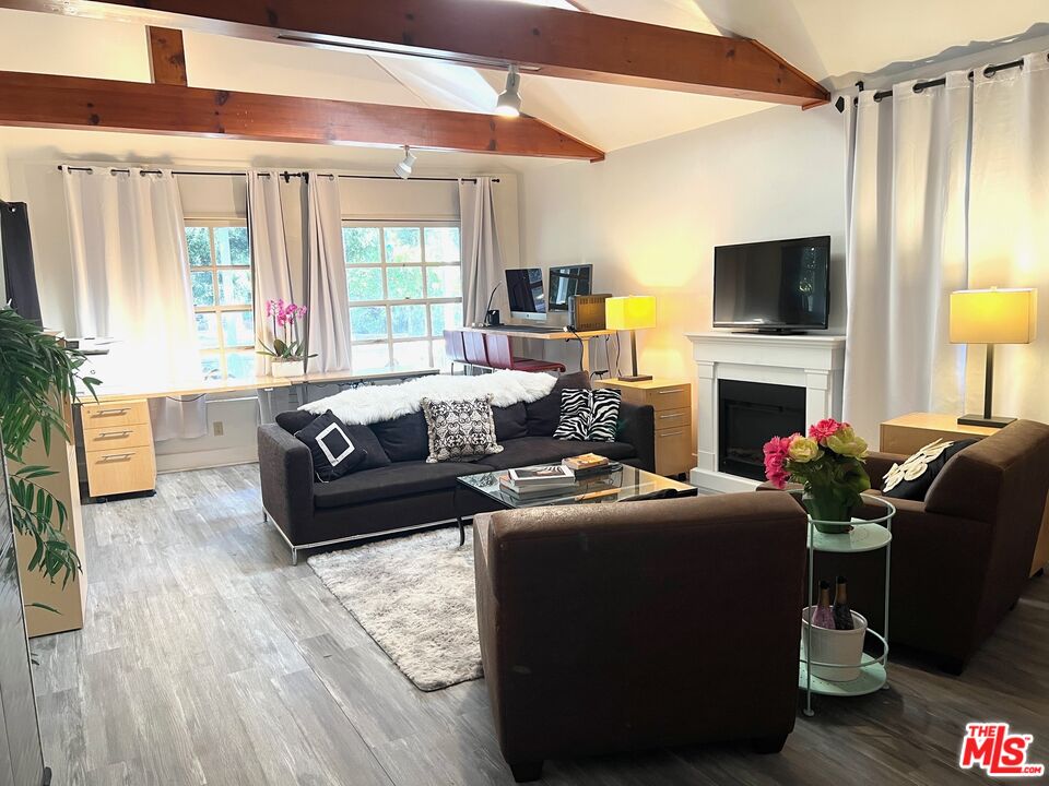 Carmelita Avenue Beverly Hills, CA 90210 - Photo 3 of 14 a living room with furniture a flat screen tv and a fireplace