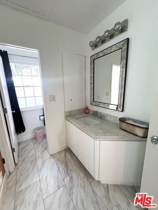 Carmelita Avenue Beverly Hills, CA 90210 - Photo 8 of 14 a bathroom with a granite countertop sink and a mirror