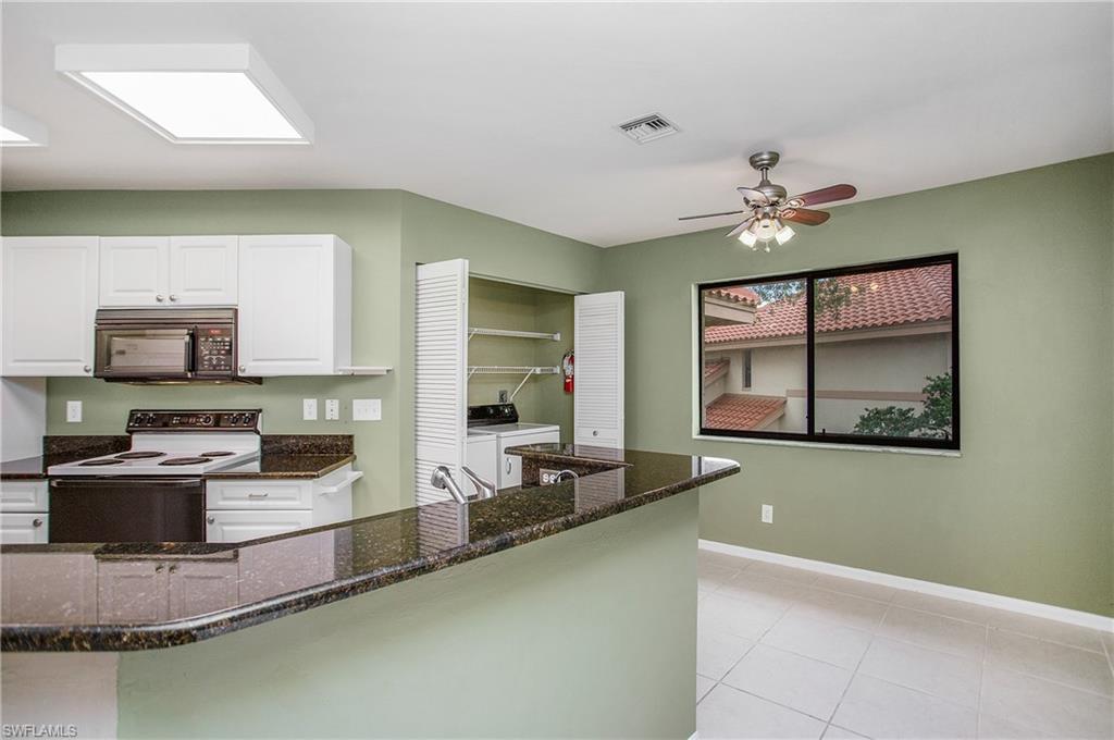 191 Bennington Drive, Unit 124 Naples, FL 34104 - Photo 11 of 26 a kitchen with kitchen island a counter top space appliances and cabinets