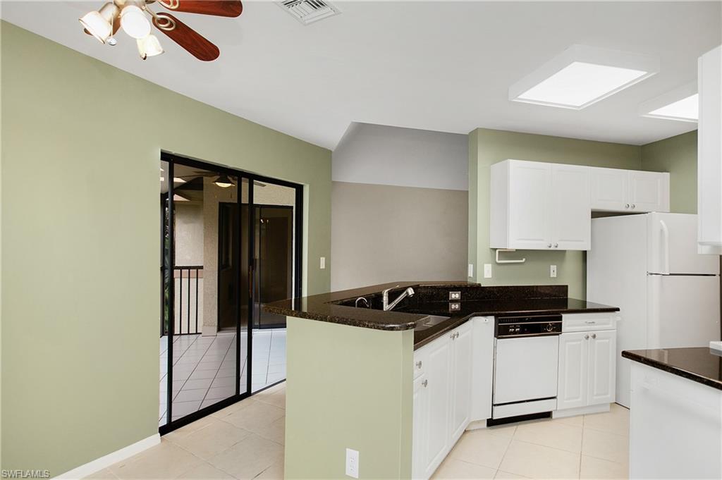 191 Bennington Drive, Unit 124 Naples, FL 34104 - Photo 13 of 26 a kitchen with a refrigerator and a stove top oven
