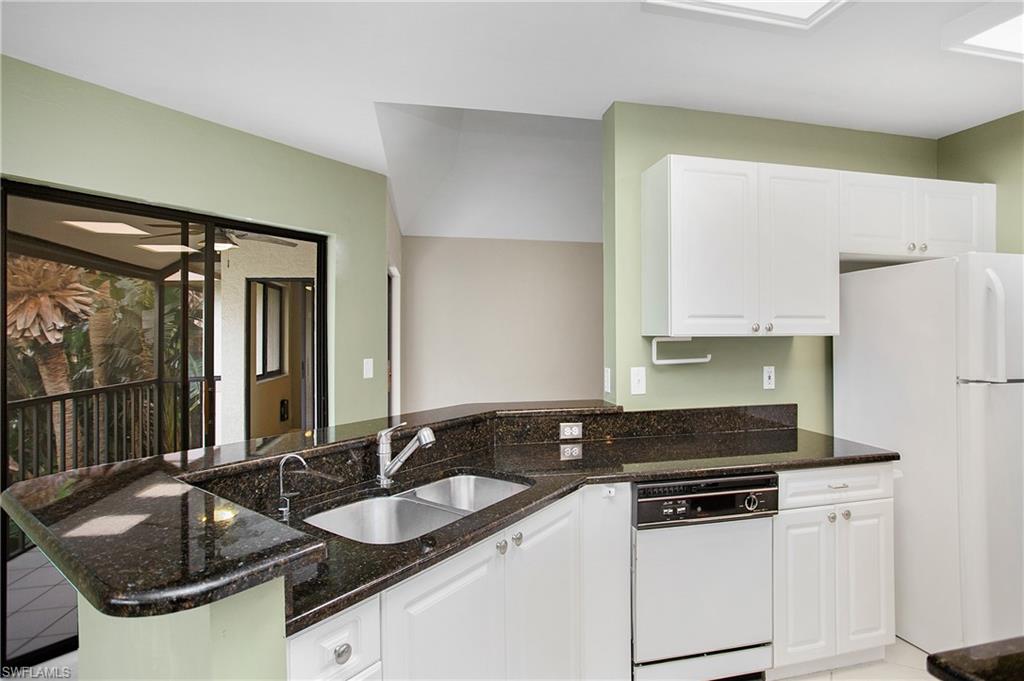 191 Bennington Drive, Unit 124 Naples, FL 34104 - Photo 14 of 26 a kitchen with granite countertop a sink and a refrigerator