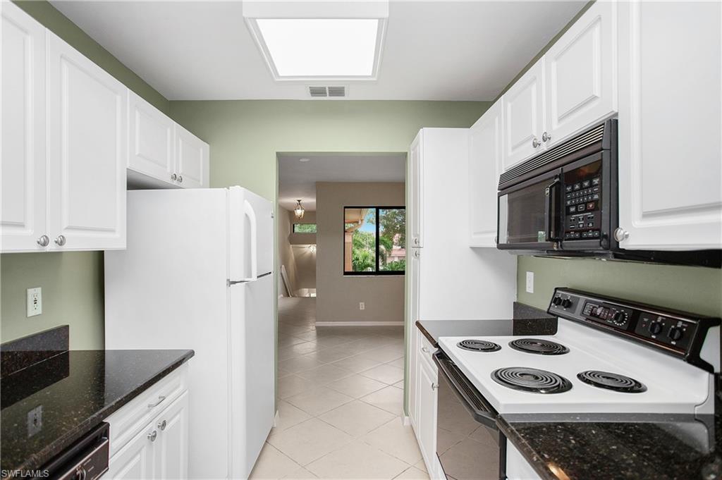 191 Bennington Drive, Unit 124 Naples, FL 34104 - Photo 15 of 26 a kitchen with stainless steel appliances granite countertop a refrigerator sink and stove