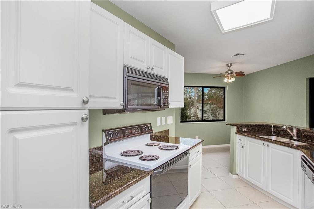 191 Bennington Drive, Unit 124 Naples, FL 34104 - Photo 16 of 26 a kitchen with a stove a sink and a refrigerator