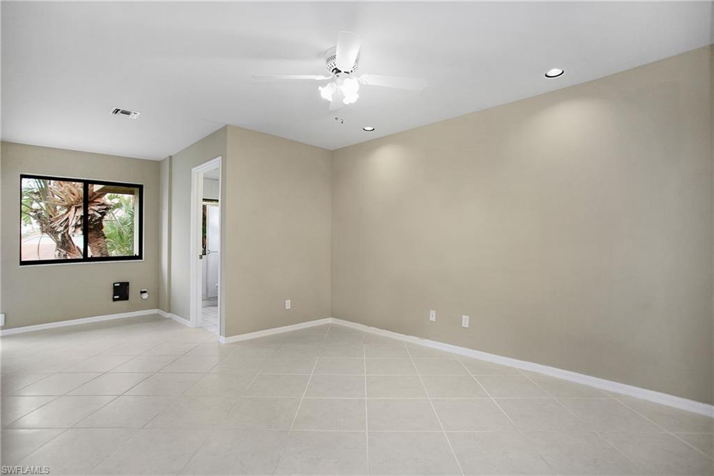 191 Bennington Drive, Unit 124 Naples, FL 34104 - Photo 18 of 26 wooden floor in an empty room with a window