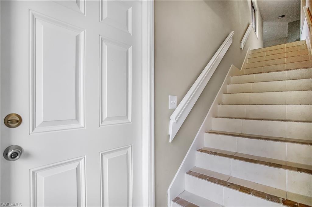 191 Bennington Drive, Unit 124 Naples, FL 34104 - Photo 3 of 26 a view of staircase with white walls and railing