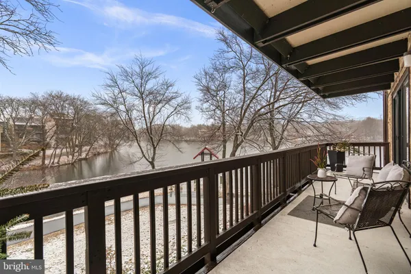 a balcony with wooden floor and outdoor seating