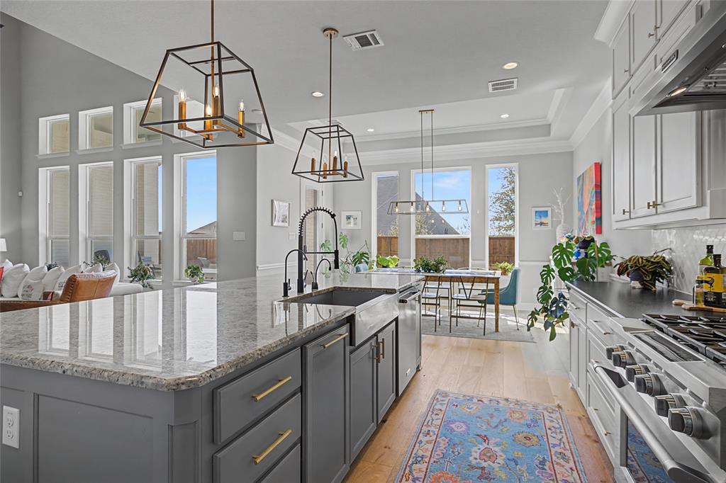 13753 Green Elm Road Fort Worth, TX 76008 - Photo 3 of 40 Large peninsula is the center of the kitchen-prep space or snack space! 6 burner KitchenAid gas range, Insta-hot water dispenser and filtered water dispenser all for efficiency and convenience.