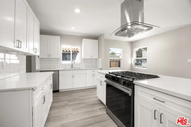 a kitchen with a stove sink and cabinets