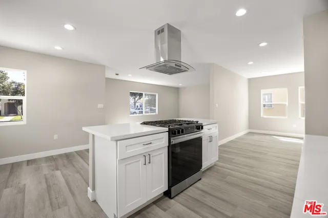a kitchen with a stove and white cabinets