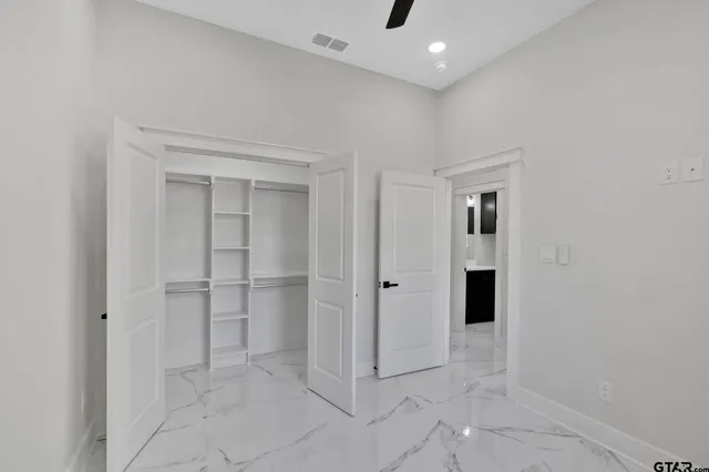 an empty room with a window and ceiling fan