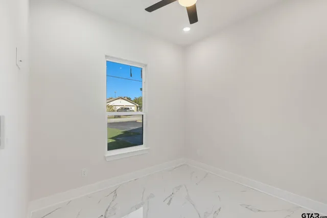 an empty room with closet and windows