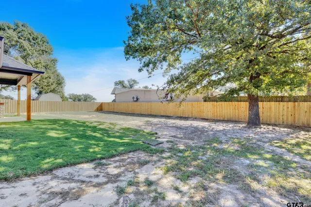 a view of an house with backyard and a tree