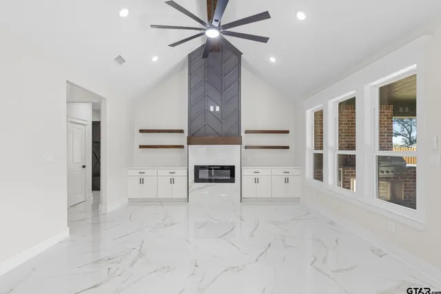 an empty room with a windows and fireplace