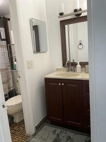 a bathroom with a sink a toilet and mirror