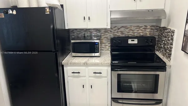 a stove top oven sitting inside of a kitchen