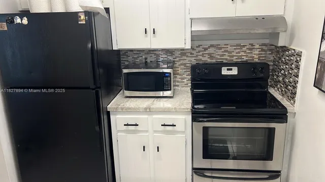 a stove top oven sitting inside of a kitchen
