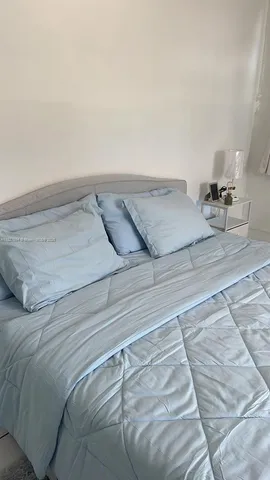 a bedroom with a bed and mirror