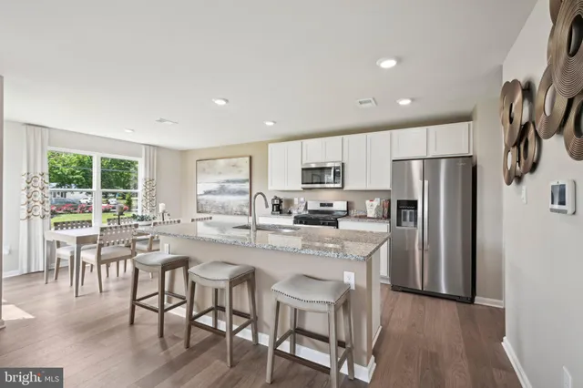 a kitchen with granite countertop a sink stove and refrigerator