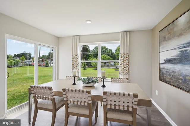 a living room with furniture kitchen appliances and a dining table