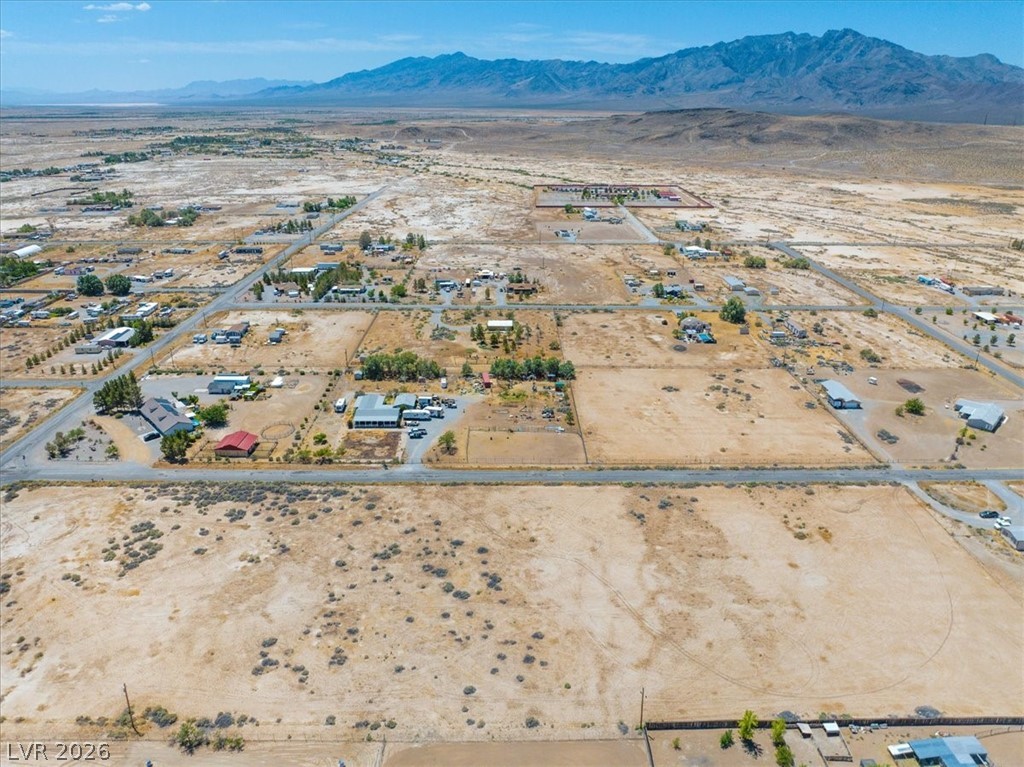 4610 Lawrence Road Pahrump, NV 89048 - Photo 37 of 42 An aerial perspective reveals vast, open terrain interspersed with residential structures and distant mountains.