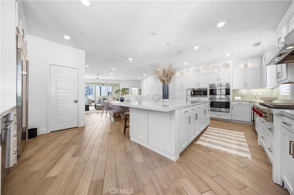 108 Catalyst Irvine, CA 92618 - Photo 43 of 60 a large white kitchen with lots of counter top space a sink stainless steel appliances and cabinets
