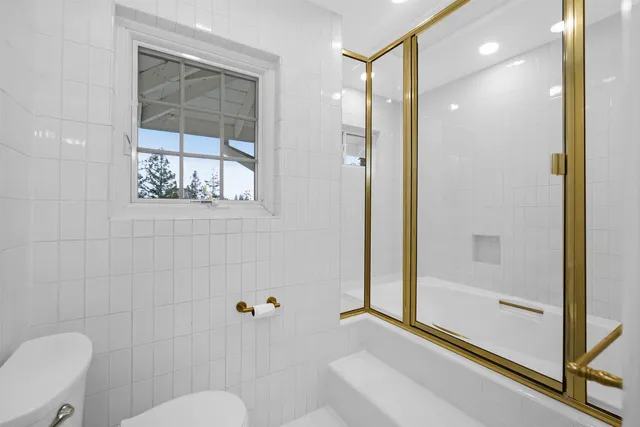 a bathroom with a granite countertop tub a sink and a glass door shower