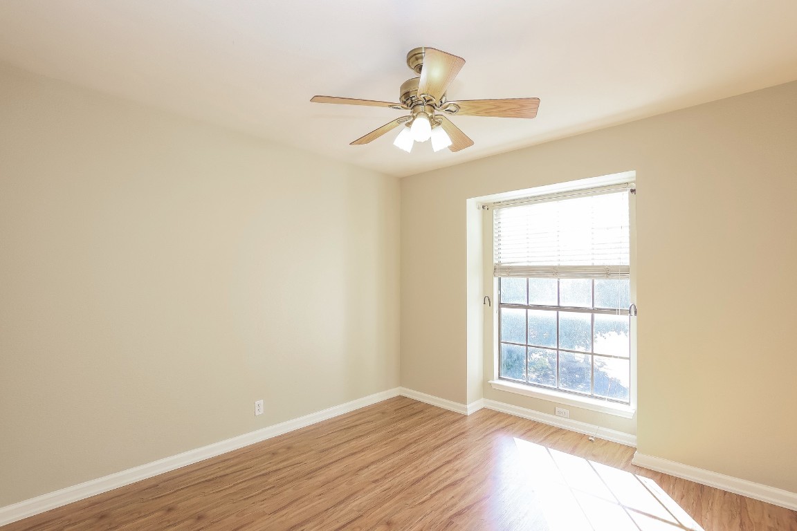 2802 Hummingbird Circle Cedar Park, TX 78613 - Photo 12 of 15 an empty room with wooden floor fan and windows