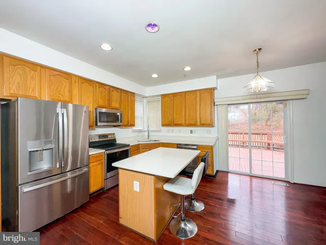 a kitchen with stainless steel appliances wooden floor dining table and chairs