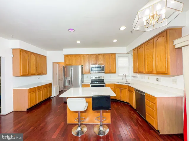 a large kitchen with a large window and wooden floor