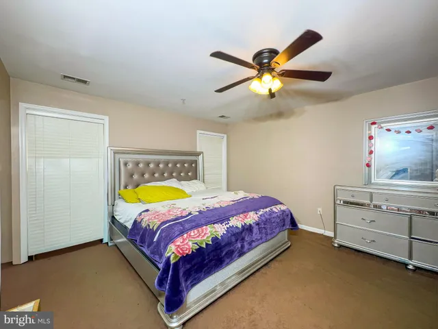 a bed room with a bed and a ceiling fan