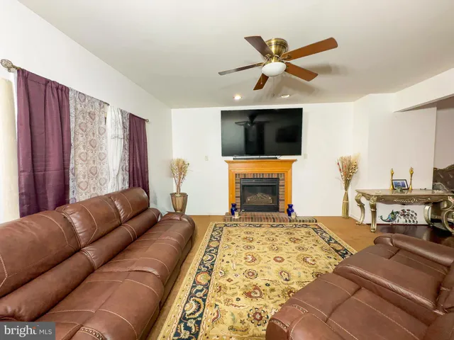 a living room with furniture ceiling fan and a flat screen tv