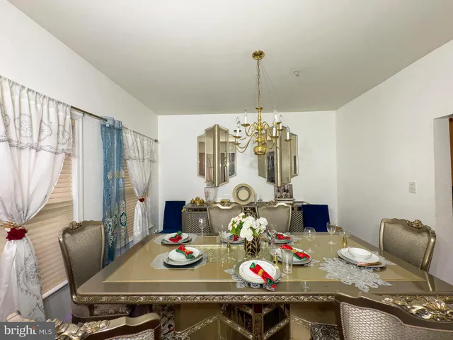 a view of a dining room with furniture a chandelier and wooden floor
