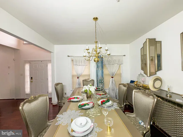 a view of a dining room with furniture a chandelier and wooden floor
