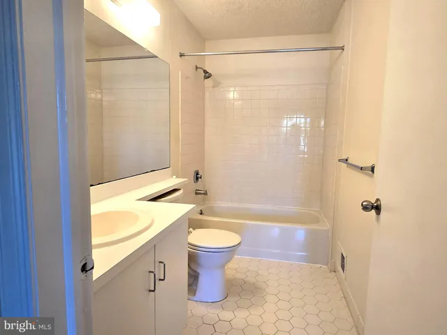 a bathroom with a granite countertop sink a toilet and shower