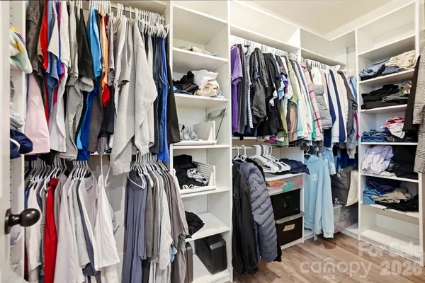a view of walk in closet with clothes and shoes