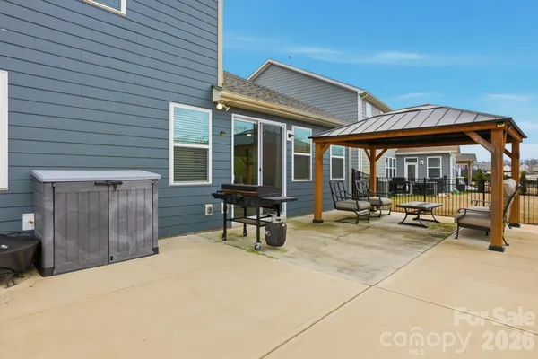 a view of a patio with a table and chairs under an umbrella