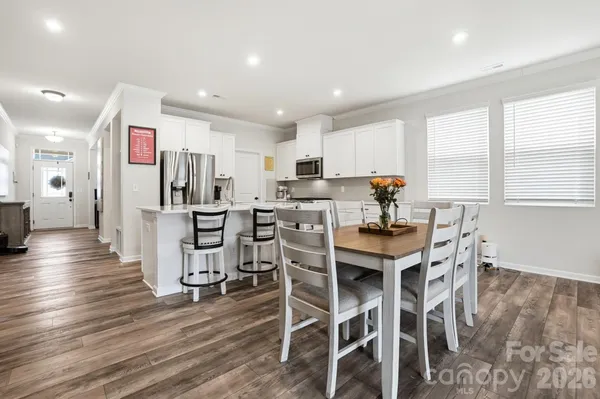 a kitchen with stainless steel appliances kitchen island granite countertop a refrigerator and wooden cabinets