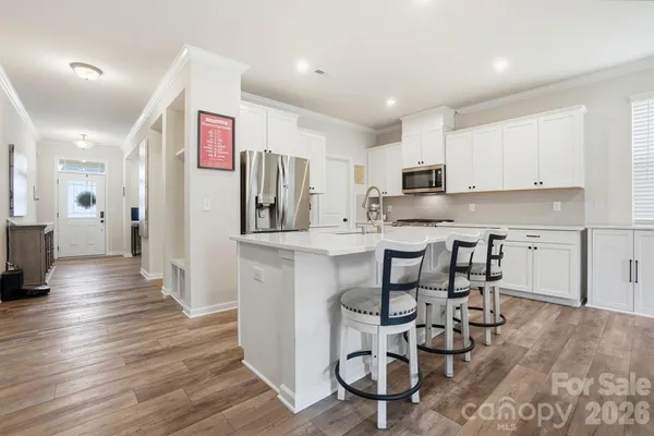 a kitchen with stainless steel appliances kitchen island granite countertop a refrigerator and a stove top oven