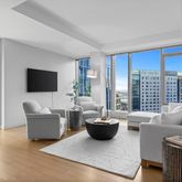 a living room with furniture potted plant and a flat screen tv