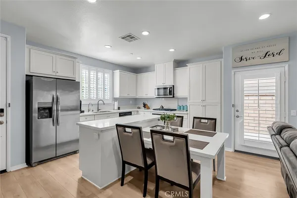 a kitchen that has a lot of cabinets a sink and appliances in it