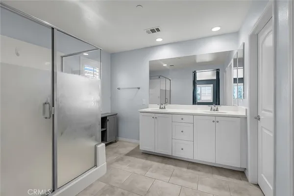 a spacious bathroom with a mirror sink and shower