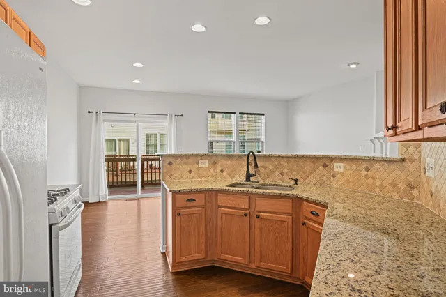 a kitchen with stainless steel appliances granite countertop a sink stove and cabinets