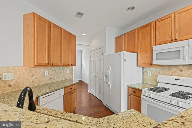 a kitchen with granite countertop a sink stainless steel appliances and cabinets