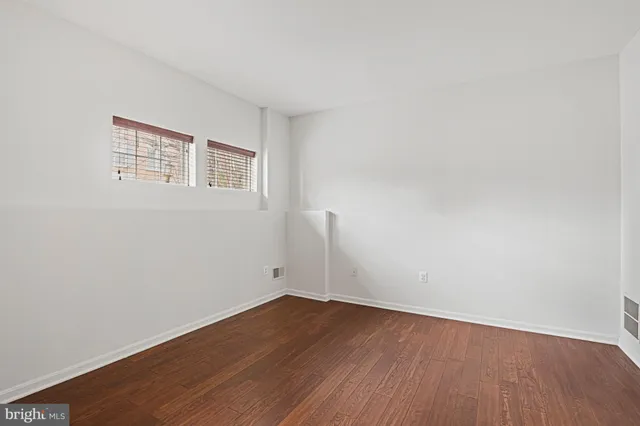 a view of a room with wooden floor and white walls
