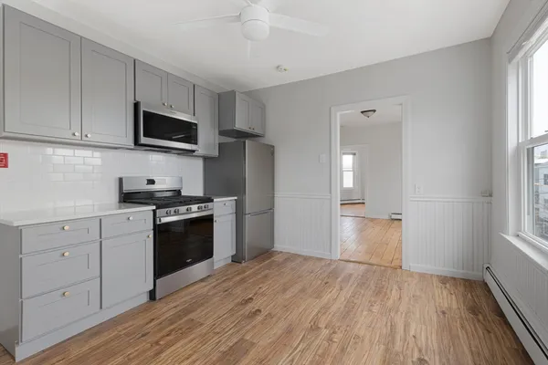 a kitchen with a refrigerator stove and white cabinets