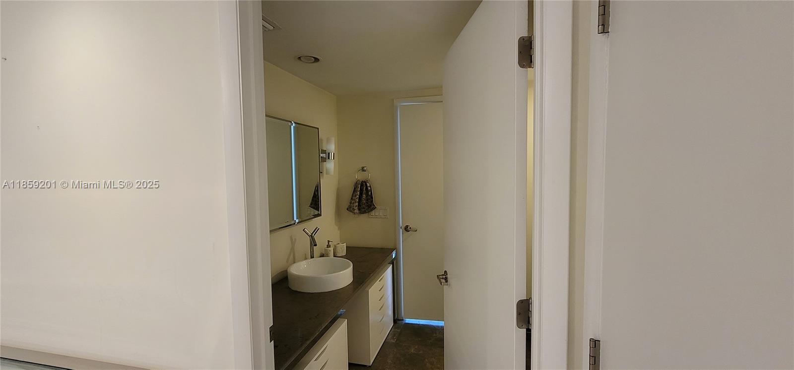 495 Brickell Avenue, Unit 420 Miami, FL 33131 - Photo 16 of 73 a bathroom with a granite countertop mirror and a sink