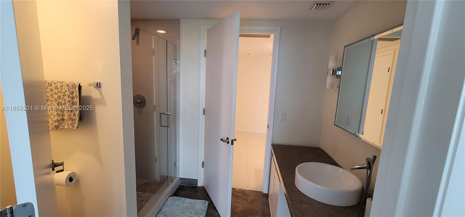 495 Brickell Avenue, Unit 420 Miami, FL 33131 - Photo 21 of 73 a bathroom with a granite countertop sink a mirror and a shower