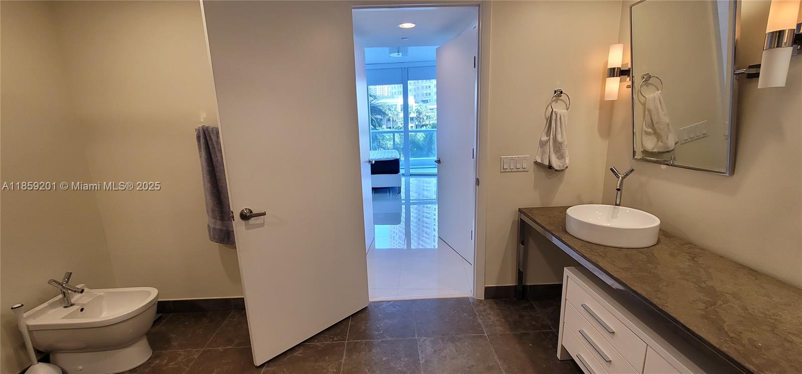 495 Brickell Avenue, Unit 420 Miami, FL 33131 - Photo 50 of 73 a bathroom with a granite countertop sink toilet and shower