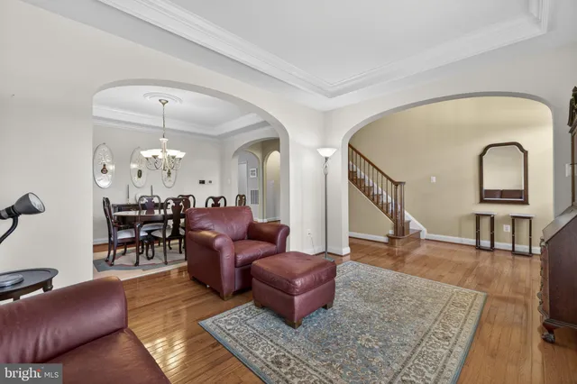 a kitchen with granite countertop a refrigerator oven a sink dishwasher and white cabinets with wooden floor